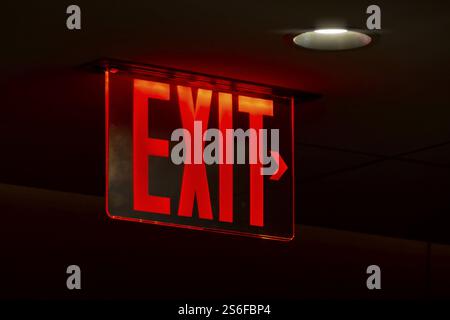 An image of a red lit exit sign Stock Photo