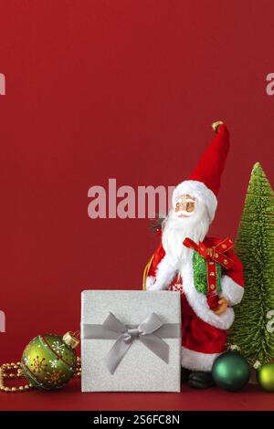 A Santa Claus figure silver gift box and red background Stock Photo