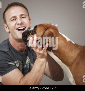 An image of a handsome laughing man with his dog Stock Photo
