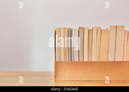 Several  different books in wooden box on a wooden table , books used and new , Stock Photo