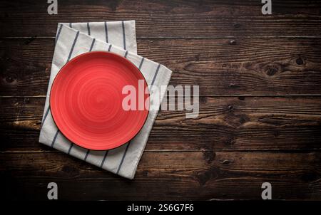 Top view of empty ceramic red plate on wooden background Stock Photo