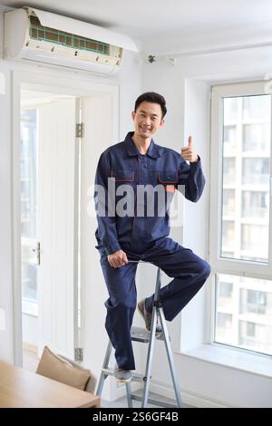 Handyman fixing the air conditioner Stock Photo