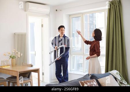 Handyman fixing the air conditioner Stock Photo