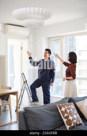 Handyman fixing the air conditioner Stock Photo