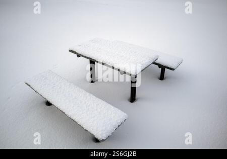 Snow-covered benches and table in the park Stock Photo