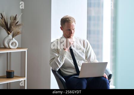 Busy business man, male investor looking at computer thinking at work. Stock Photo