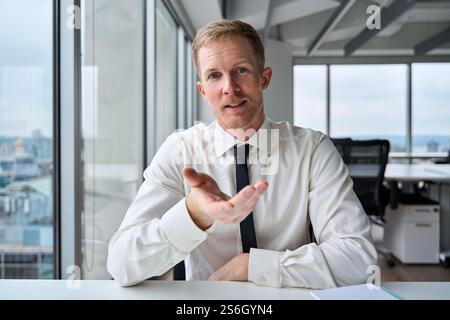 Young businessman executive talking to web camera having virtual meeting. Stock Photo