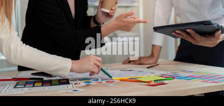 Dynamic UX UI team discussing design strategies while reviewing concepts on a tablet in a modern office Stock Photo