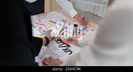 Dynamic UX UI team reviewing mobile app wireframes and sketches during a collaborative design session Stock Photo