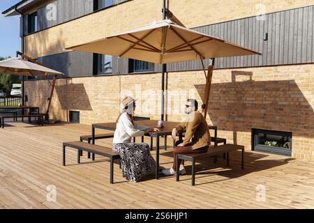 Young adult couple sitting outside having conversation Stock Photo