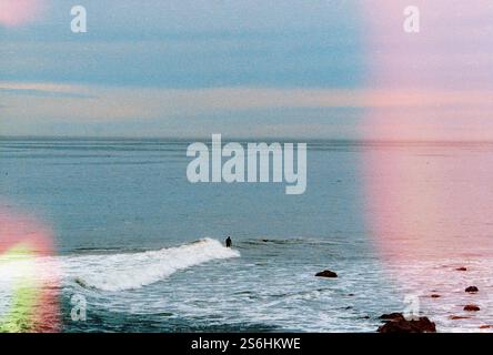 Waves Crashing Against the Shore with Subtle Light Leaks Stock Photo