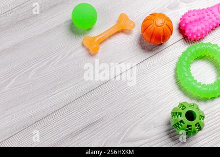 Pet supplies and toys. Playful toys such as balls, a rubber ring and chewing bones on the floor. Top view. Stock Photo