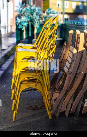 stacked yellow metal cafe chairs fish quay union quay Tynemouth north shields Stock Photo