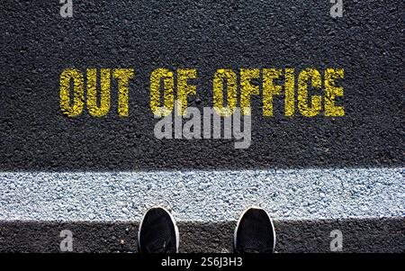 Out of office message written on asphalt road. Conceptual out of office symbol. Copy space. Stock Photo