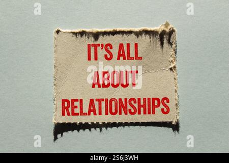 It’s all about relationships message written on ripped torn paper piece on gray background. Conceptual it’s all about relationships symbol. Copy space Stock Photo