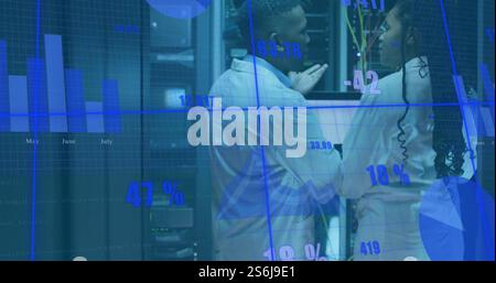 Image of diagrams and data processing over biracial workers in server room Stock Photo