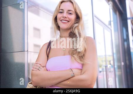 Confident Blonde Woman Posing Outdoors in Stylish Summer Outfit Stock Photo
