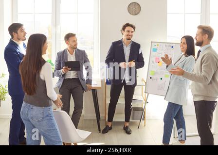 Team Members Actively Discussing Ideas During a Creative Brainstorming Session in a Bright Office Stock Photo