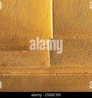 Yellow-textured wall featuring geometric patterns and clear lines, showcasing stunning simplicity and color vibrancy. Stock Photo