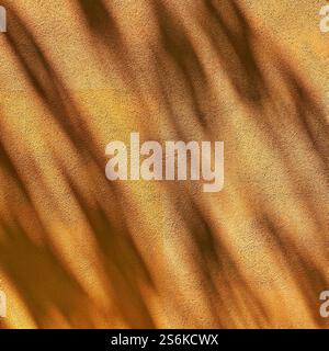Abstract golden-toned texture showcasing a soft interplay of shadows and light patterns, evoking warmth, elegance, and a sense of natural beauty. Stock Photo