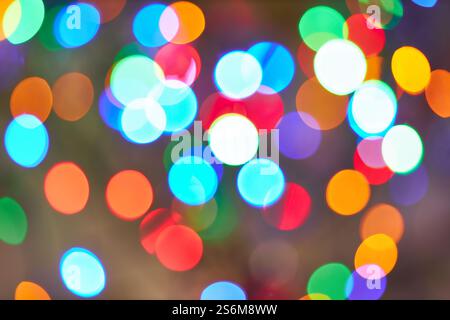 Festive bokeh lights in various colors create a vibrant and joyful background. The image features blurred circular shapes in green, red, blue, orange, Stock Photo