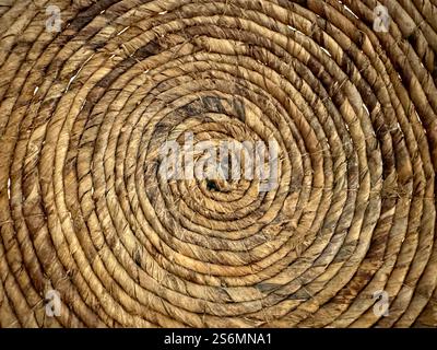 Random spiral rattan or wicker art and craft, round circle spiral synthetic rattan basket weave accessories or decoration on wall. Stock Photo