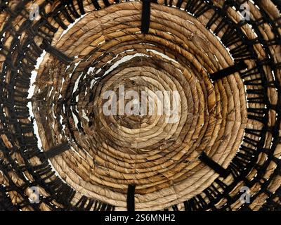 Random spiral rattan or wicker art and craft, round circle spiral synthetic rattan basket weave accessories or decoration on wall. Stock Photo