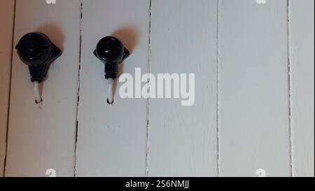 Black Bakelite rotary switch on white painted wooden wall Stock Photo