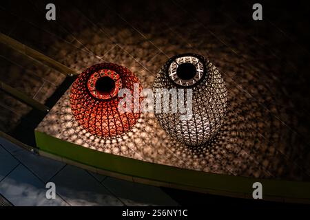 Two vases with a light inside of them are on a green table. The vases are lit up and cast shadows on the table Stock Photo