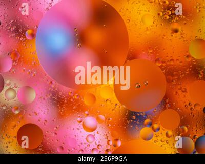 Abstract composition featuring vibrant circular shapes, created by oil droplets in water with a colorful gradient background. This striking image evok Stock Photo