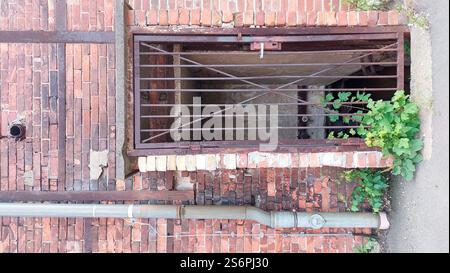 Door with metal grille in old brick building Stock Photo