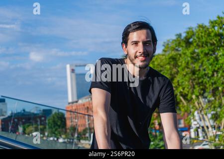 Young latin man standing smiling relaxed and calm in the city Stock Photo