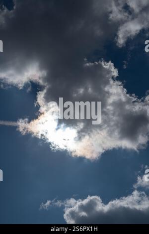 photo Spectacular Celestial Phenomenon: Sunlight Piercing Through Dark Clouds in a Vibrant Blue Sky Creating a Contemporary Natural Masterpiece Stock Photo