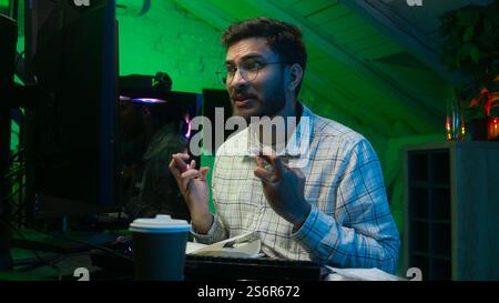 Worried Indian Arabian man guy streamer programmer hacker computer hope cross fingers loss failure error lost crypto freelancer crash studio home Stock Photo