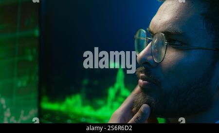 Indian Arabian man programmer hacker thinking looking computer chart guy trader analysis trading crypto currency database male technology IT Stock Photo