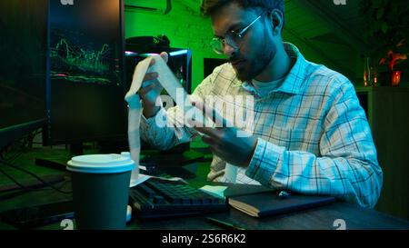 Caucasian focused man programmer checking coding guy coder male professional digital engineer IT support drinking coffee typing working on desktop Stock Photo