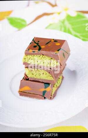 Dubai chocolate with pistachio filling on a white plate. Stock Photo