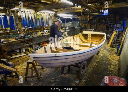 The last builder of traditional rowing boats or cobles on the River Tweed, Ian Simpson at work in his workshop in Norham Stock Photo