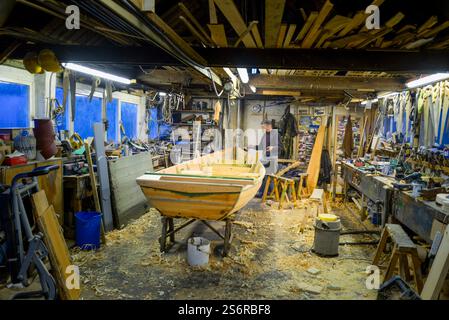 The last builder of traditional rowing boats or cobles on the River Tweed, Ian Simpson at work in his workshop in Norham Stock Photo