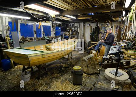 The last builder of traditional rowing boats or cobles on the River Tweed, Ian Simpson at work in his workshop in Norham Stock Photo