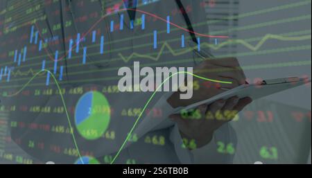 Analyzing financial data on tablet, business professional with stock market image Stock Photo