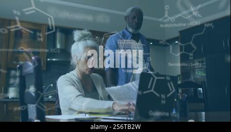 Chemical formulas and molecular structures image over people working on laptop Stock Photo
