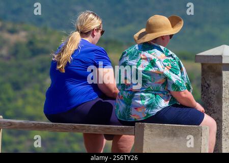 Antigua and Barbuda, West Indies, Antigua Island, two round women sitting on a bench Stock Photo