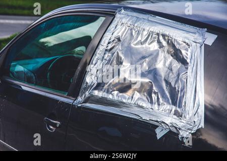 Car window repaired with plastic and tape after theft Stock Photo