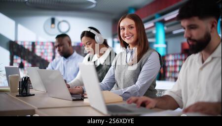 University Student At Library With Laptop Doing Assignment And Preparing For Exam Stock Photo