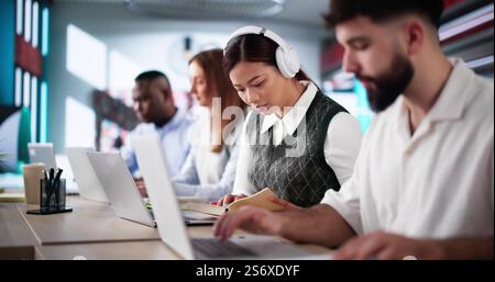 University Student At Library With Laptop Doing Assignment And Preparing For Exam Stock Photo