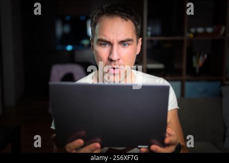 Amazed happy guy using digital tablet looking shocked about social media news, astonished man shopper consumer surprised excited by online win isolate Stock Photo