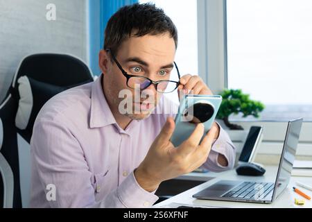 bald youth looked very surprised when he saw his smartphone screen, advertisements and copy space. Stock Photo