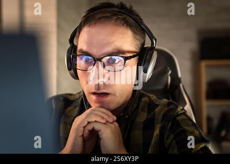 Amazed happy guy with open mouth using digital tablet looking shocked about social media news, astonished man shopper consumer surprised excited by on Stock Photo