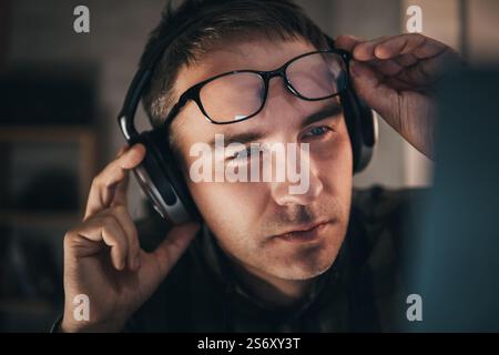 photo of handsome man at home distance work, video call seminar. the sound engineer works at home. Stock Photo